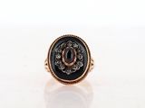 a close up of a gold ring with a black stone in it