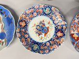 three plates with different designs are sitting on a table