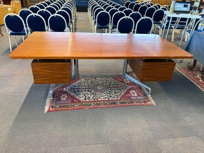 une photo montrant une table de réunion et des chaises dans une grande salle