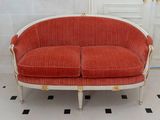 a red and white couch in a room with a black and white checkered floor