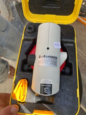 quelqu'un tient un outil posé par terre dans un coffret jaune