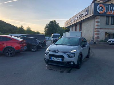 a car parked in front of a building with a sign on it