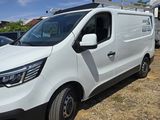 a white van parked in a lot with other vehicles in the background
