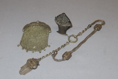 a silver purse, a chain, and a keychain on a table