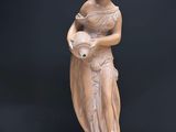 a statue of a woman holding an apple on a table