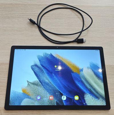 a tablet that is sitting on a table with a cord attached to it
