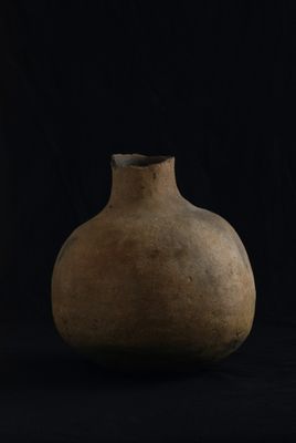 un vieux vase sur fond noir, avec un fond noir