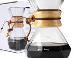 une cafetière en verre avec une poignée en bois, à côté d'une boîte de café
