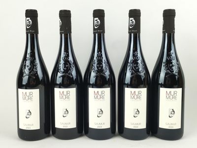quatre bouteilles de vin sont alignées sur une surface blanche
