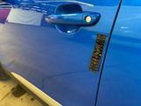 a close up of a car door handle with a sticker on it