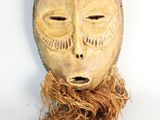 une image représentant un masque en bois aux longs cheveux sur fond blanc