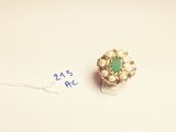 an image of a gold ring with a green stone surrounded by pearls