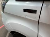 a close up of a white car with a sticker on it
