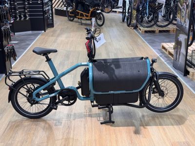 un vélo bleu avec un sac noir à l'arrière