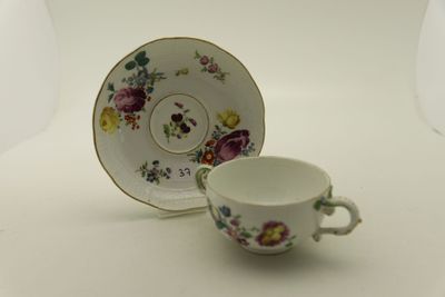 une petite tasse et une soucoupe posées sur une table