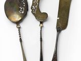 three spoons and a knife on a white surface