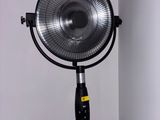 a fan that is on a stand in the corner of a room