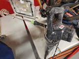 une perceuse posée sur une table, entourée de nombreux outils