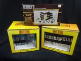 three boxed boxes of miniature model houses on a black background