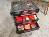 a black tool box with two red drawers on top of it