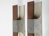 two pieces of metal hanging on the wall next to each other