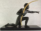 statue of a man holding a surfboard on a black base