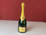 une bouteille de champagne posée sur un comptoir à côté de bouteilles de vin