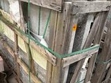 a pile of old windows in the back of a building