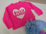 a pink shirt with a heart on it next to a blue tutu