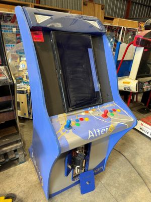 une photo d'une borne d'arcade bleue et blanche dans un garage