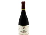 the bottle of red wine is sitting on a white surface