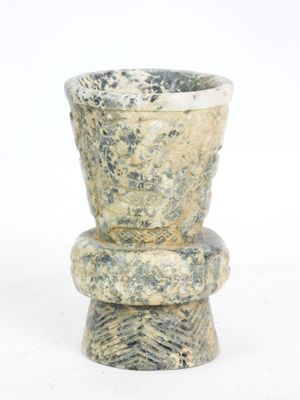 a stone vase that is sitting on top of a table