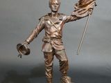 bronze statue of a man holding a flag and a flag pole