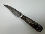 a knife with writing on it sitting on a table