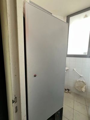 un réfrigérateur qui se trouve dans un coin de la salle de bains