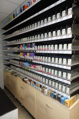 un grand présentoir de cigarettes dans un magasin, à côté d'un comptoir