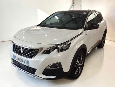 La voiture blanche est garée dans une pièce blanche au sol blanc.