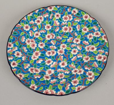 un gros plan d'une assiette ornée de fleurs sur fond bleu
