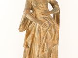 an old statue of a woman sitting on a chair with a hat on her head