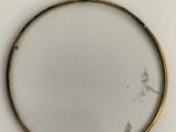 an image of a gold plate with a picture of a bird in it
