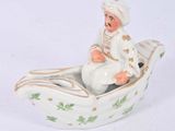 a figurine of a man in a boat on a white surface