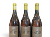 three bottles of wine sitting next to each other on a white surface