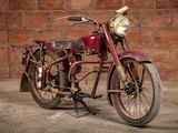 a red motorcycle that is parked in front of a brick wall