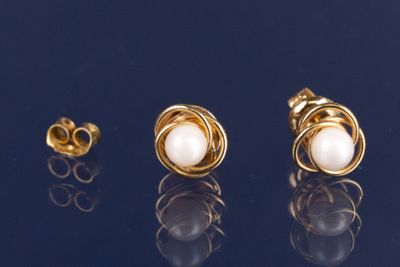 trois paires de boucles d'oreilles en or et perles sur un fond noir