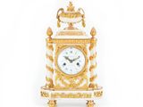 une horloge dorée et blanche posée sur une table