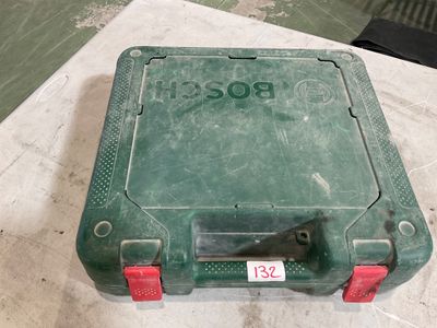 une valise en plastique verte avec une poignée rouge posée par terre