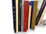 a lot of books that are stacked on a shelf
