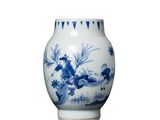 un vase bleu et blanc posé sur une surface blanche