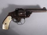 an old revolver with a wooden handle on a white surface