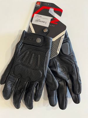 a close up of a pair of black leather gloves on a white surface